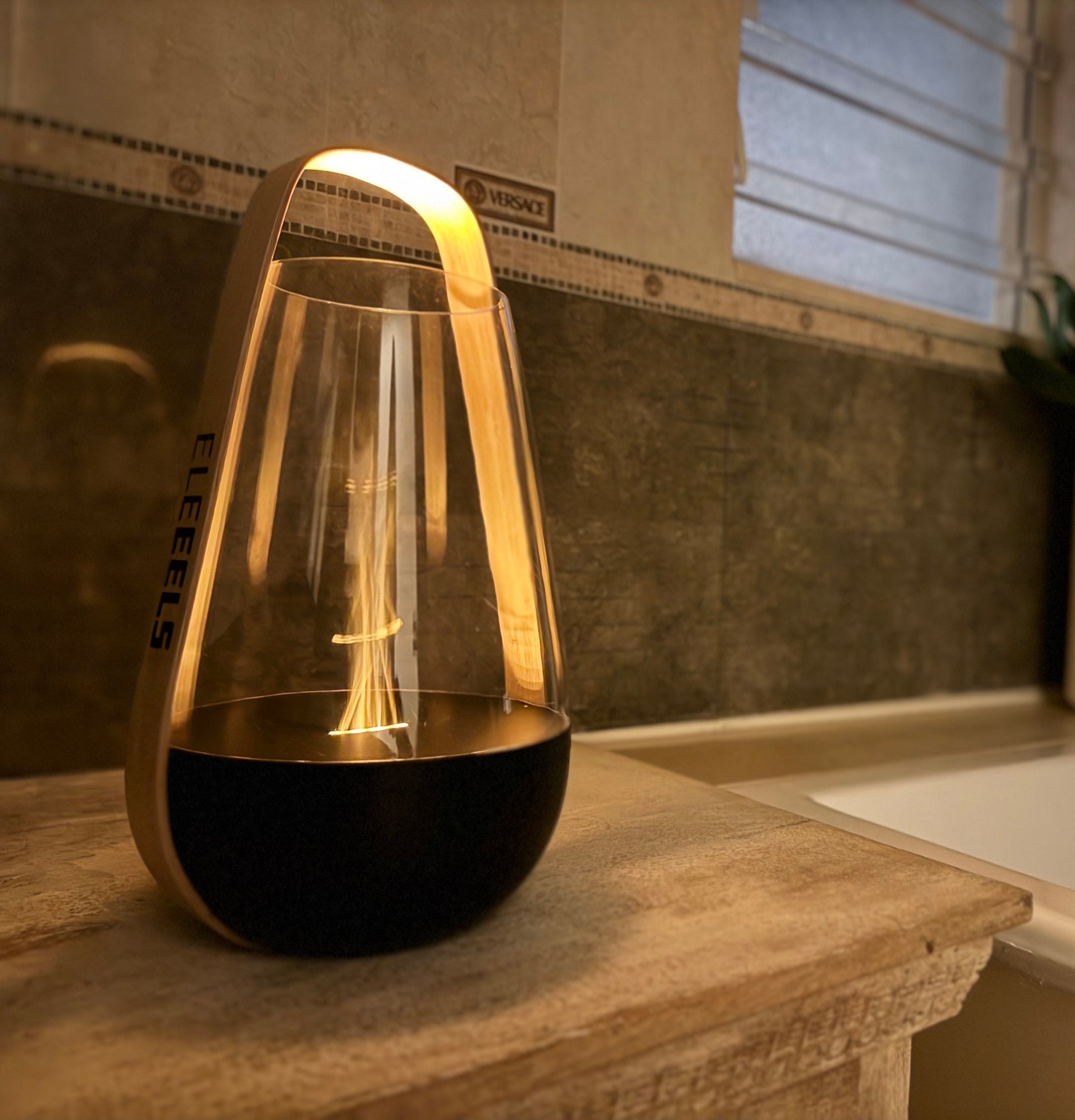 Der EleEELS S5 Aroma Diffusor in Laternenform steht auf einer Holzoberfläche und verströmt warmes Licht.